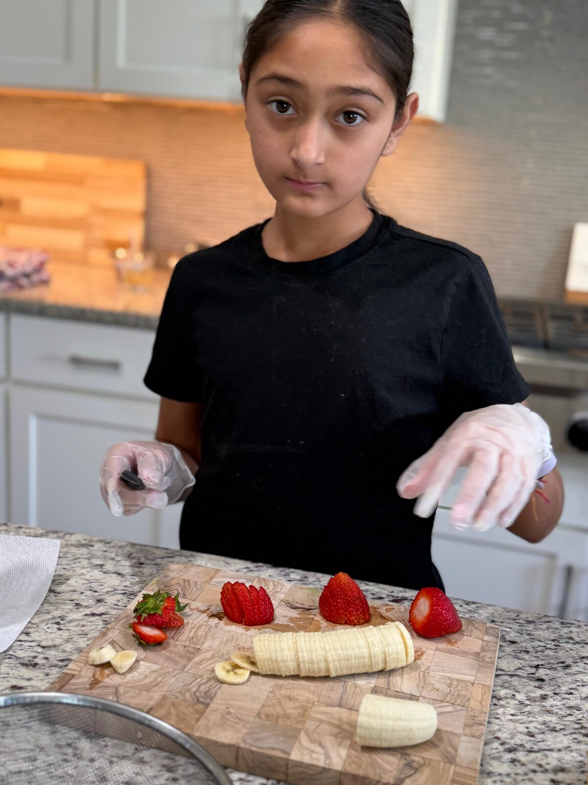 Arianna arranging fresh fruit on a cutting board